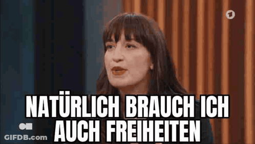 Woman Sitting In Front Of Curtain Saying Naturlich Brauche Ich Auch Freiheiten GIF
