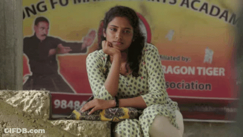 Woman Sitting In Front Of Dragon Tiger Sign GIF