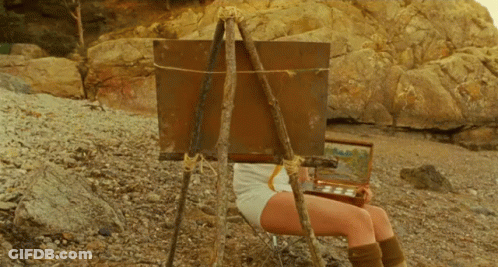 Woman Sitting In Front Of Easel With Painting GIF