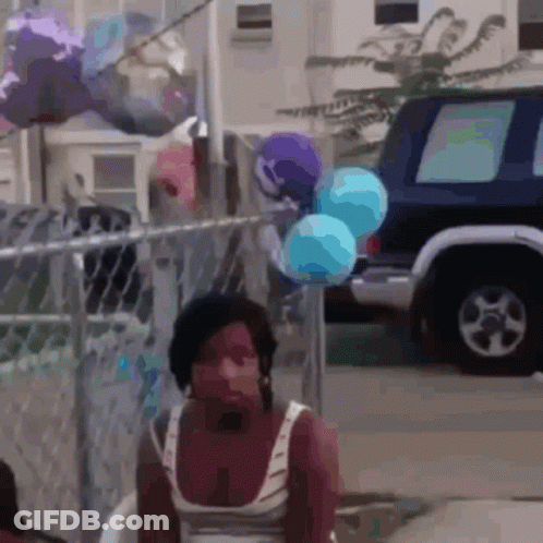 Woman Sitting In Front Of Fence With Balloons GIF
