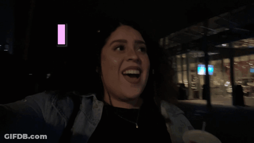 Woman Sitting In Front Of Man Playing Guitar In Dark Room GIF