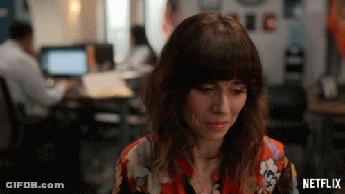 Woman Sitting In Front Of Netflix Sign GIF