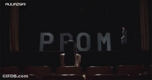 Woman Sitting In Front Of Prom Sign GIF