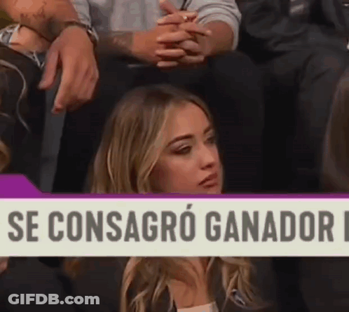 Woman Sitting In Front Of Se Consagro Ganador Sign GIF