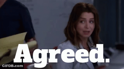 Woman Sitting In Front Of Sign Reading Agreed GIF