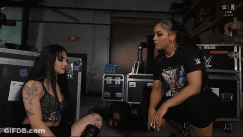 Woman Sitting In Front Of WWE Event Sign GIF