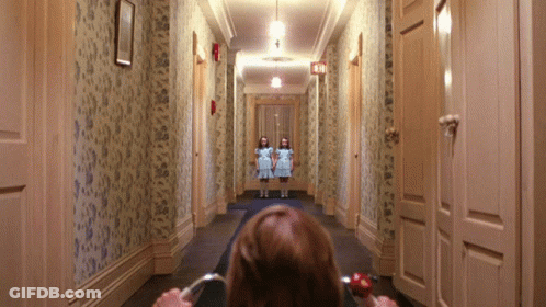 Woman Sitting In Hallway Looking At Two Girls GIF