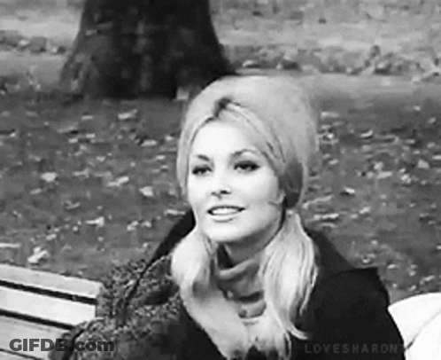 Woman Sitting In Park With Hat And Scarf GIF
