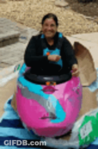 Woman Sitting In Pink Kayak On Beach Towel GIF