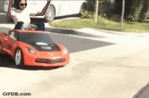 Woman Sitting In Red Toy Car GIF