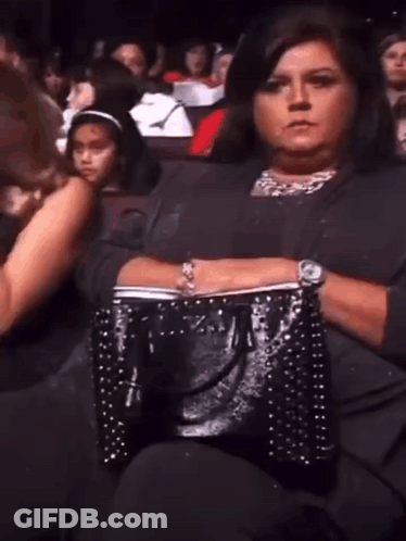 Woman Sitting In Theater With Black Purse GIF