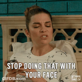 Woman Sitting On Bed Holding Cell Phone Making Face GIF