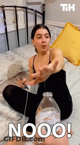 Woman Sitting On Bed Holding Phone And Nooo Water Bottle GIF