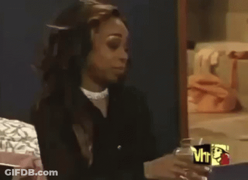 Woman Sitting On Bed Holding Wine And Talking GIF