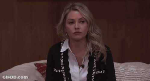 Woman Sitting On Bed In Black Cardigan With Pearls GIF