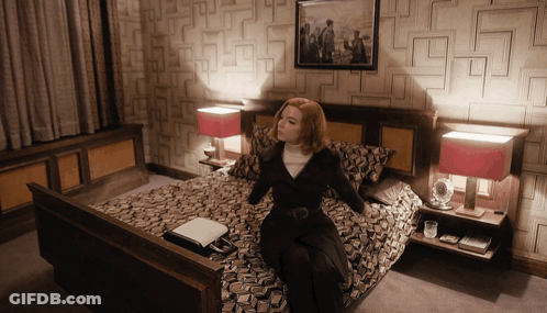Woman Sitting On Bed With Picture Above GIF