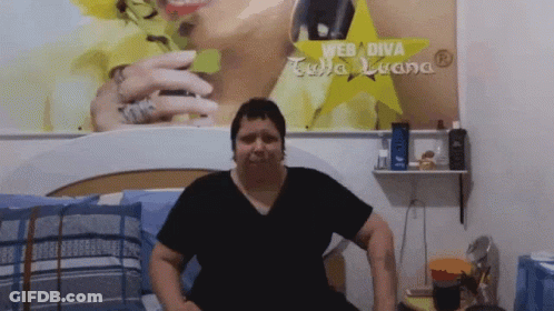 Woman Sitting On Bed With Web Diva Sign GIF