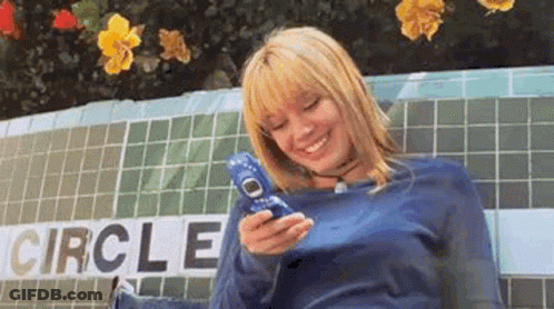 Woman Sitting On Bench Holding Cell Phone GIF