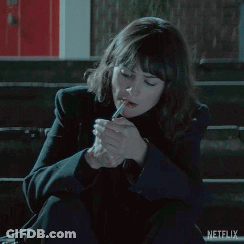 Woman Sitting On Bench Lighting Cigarette GIF