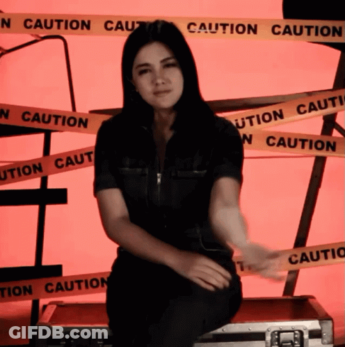 Woman Sitting On Briefcase With Caution Tape GIF