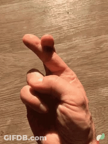 Woman Sitting On Couch Fingers Crossed GIF