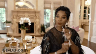 Woman Sitting On Couch Holding Perfume Bottle GIF