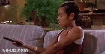 Woman Sitting On Couch Holding Remote And Smoking GIF
