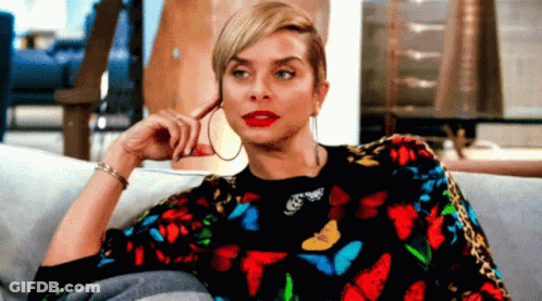Woman Sitting On Couch In Butterfly Sweater GIF