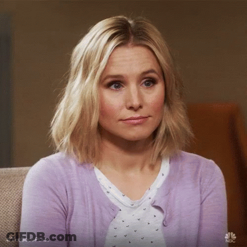Woman Sitting On Couch In Purple Cardigan Making Funny Face GIF
