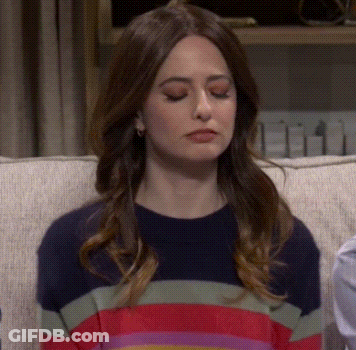 Woman Sitting On Couch In Striped Sweater Making Funny Face GIF