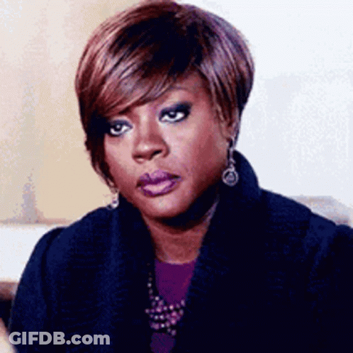 Woman Sitting On Couch In Sweater And Earrings GIF