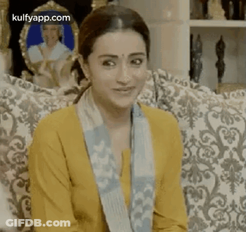 Woman Sitting On Couch In Yellow Shirt And Blue Scarf GIF