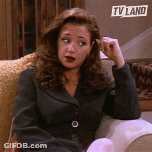 Woman Sitting On Couch Under TV Land Logo GIF