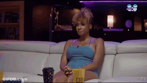 Woman Sitting On Couch With Coffee And Popcorn GIF