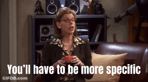 Woman Sitting On Couch With Coffee Says You'll Have To Be More Specific GIF