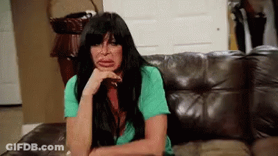 Woman Sitting On Couch With Hand On Chin GIF