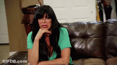 Woman Sitting On Couch With Hand On Chin GIF