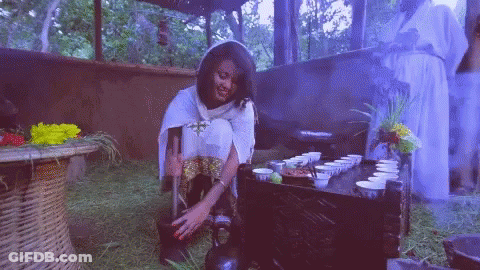 Woman Sitting On Ground At Table With Cups GIF