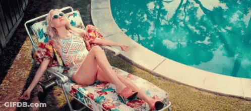 Woman Sitting On Lawn Chair By Pool GIF