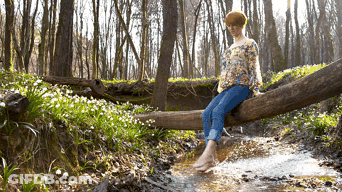 Woman Sitting On Log In Stream GIF