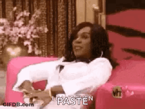 Woman Sitting On Pink Couch Holding Paper Smiling GIF