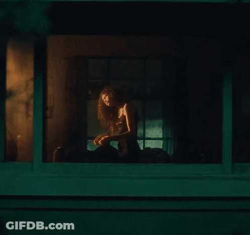 Woman Sitting On Porch Looking Out Window At Night GIF