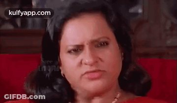Woman Sitting On Red Couch Making Angry Face GIF