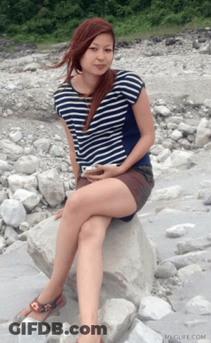 Woman Sitting On Rock With Muglife Watermark GIF