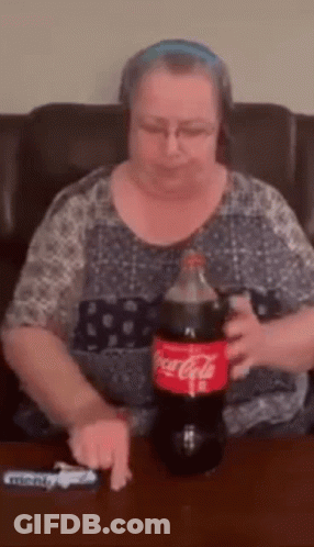 Woman Sitting With Coca Cola Bottle And Lighter GIF