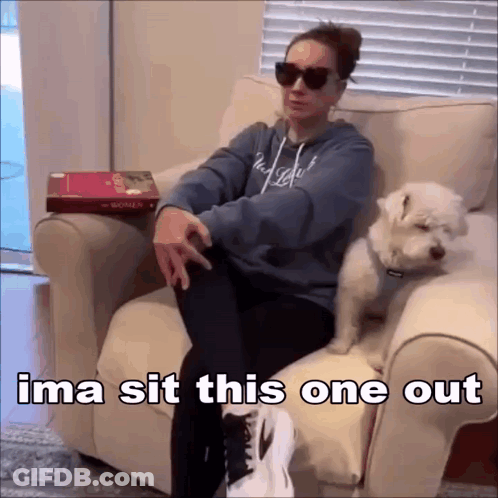Woman Sitting With Dog On Lap And Book On Table GIF