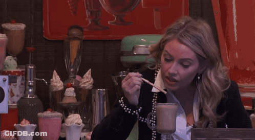 Woman Sitting With Spoon In Mouth GIF