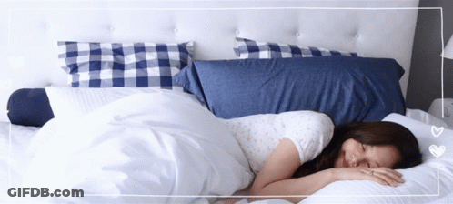 Woman Sleeping On Bed With Blue And White Pillows GIF