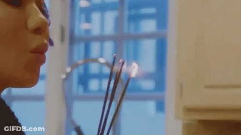 Woman Smelling Candle By Window GIF
