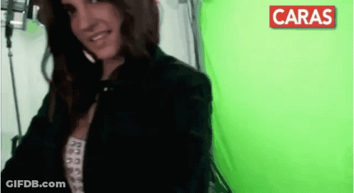 Woman Smiles At Green Screen With Red Caras GIF